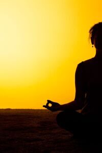 woman-practicing-yoga-sunset-light